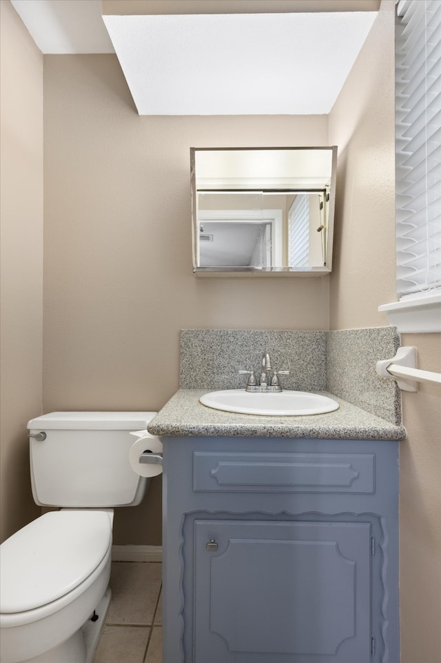 bathroom with vanity, toilet, and tile patterned flooring