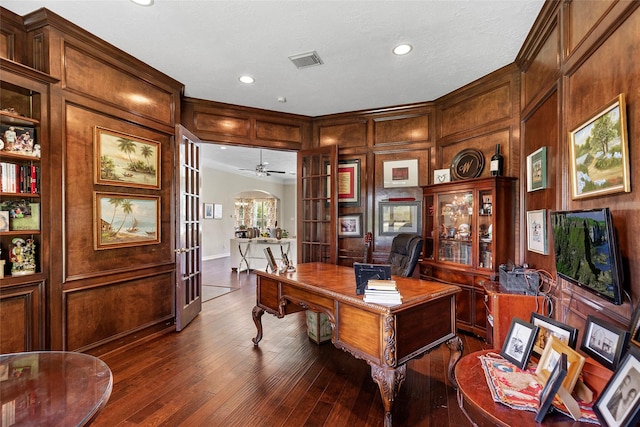 home office with french doors, ceiling fan, crown molding, and dark wood-type flooring