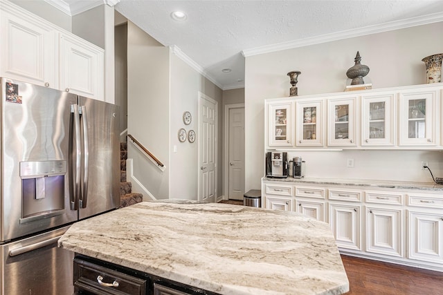 kitchen featuring stainless steel refrigerator with ice dispenser, white cabinets, dark wood-type flooring, and light stone countertops