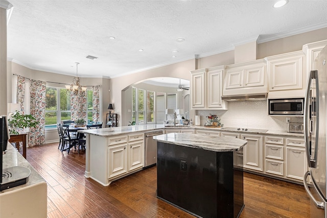 kitchen featuring decorative light fixtures, stainless steel appliances, kitchen peninsula, and a center island