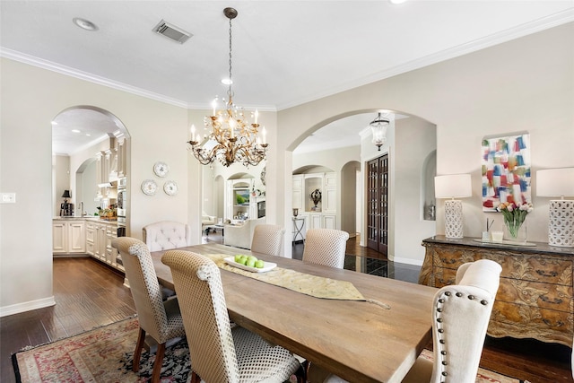 dining room with sink, ornamental molding, a notable chandelier, and dark hardwood / wood-style floors