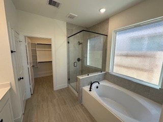 bathroom with vanity, hardwood / wood-style floors, and shower with separate bathtub