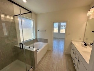 bathroom featuring vanity, hardwood / wood-style floors, and plus walk in shower