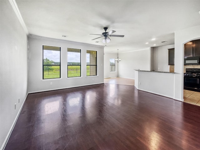 unfurnished living room featuring ceiling fan with notable chandelier, crown molding, and wood-type flooring