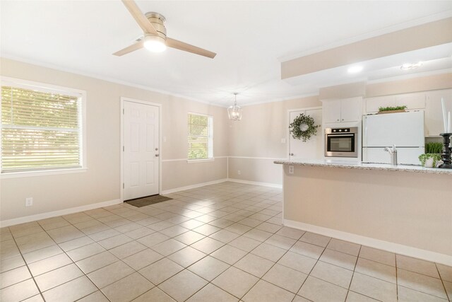 kitchen with white fridge, a healthy amount of sunlight, stainless steel oven, and decorative light fixtures