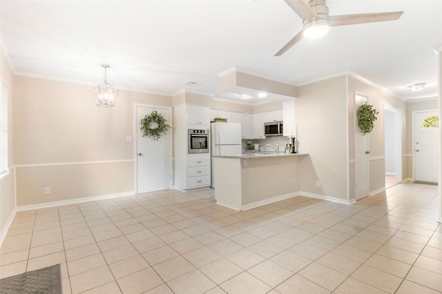 kitchen with kitchen peninsula, white cabinets, appliances with stainless steel finishes, ornamental molding, and light stone counters