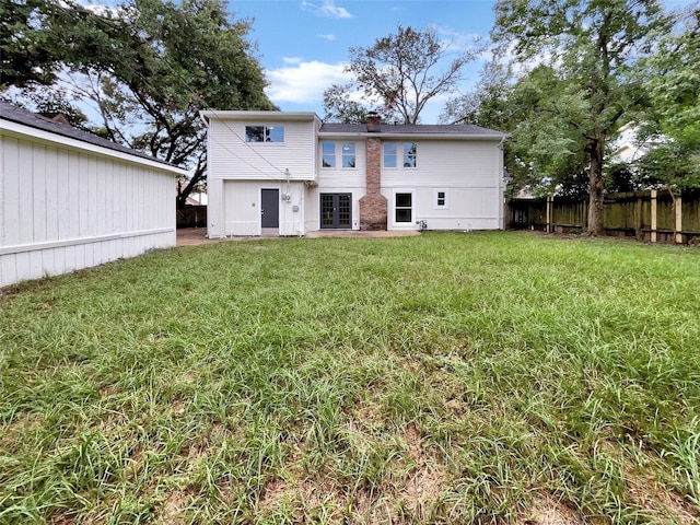 rear view of house featuring a lawn