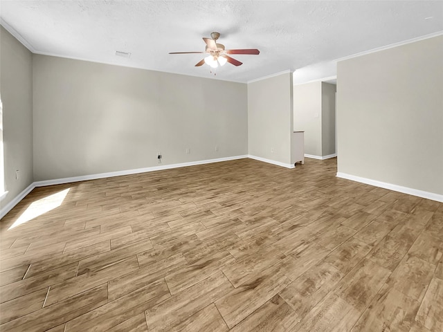 empty room with a textured ceiling, wood finished floors, a ceiling fan, and ornamental molding