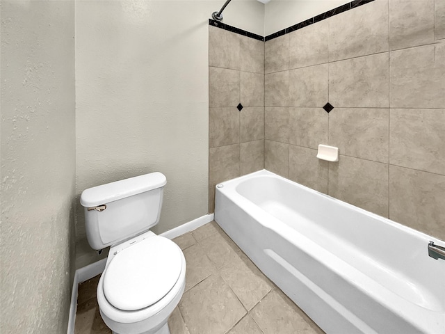 bathroom featuring tile patterned flooring, baseboards, toilet, shower / bath combination, and a textured wall