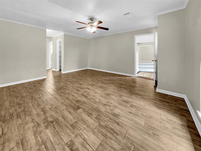 empty room with a textured ceiling, ceiling fan, and crown molding