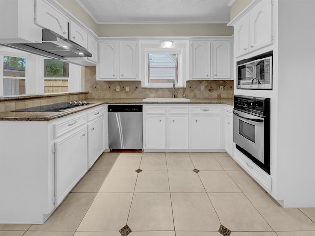 kitchen with backsplash, white cabinets, appliances with stainless steel finishes, and a sink