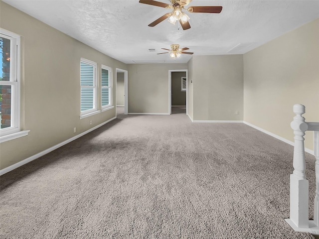 unfurnished room with carpet flooring, ceiling fan, a healthy amount of sunlight, and a textured ceiling