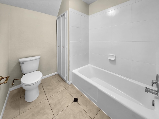 bathroom featuring bathing tub / shower combination, tile patterned flooring, a textured ceiling, and toilet