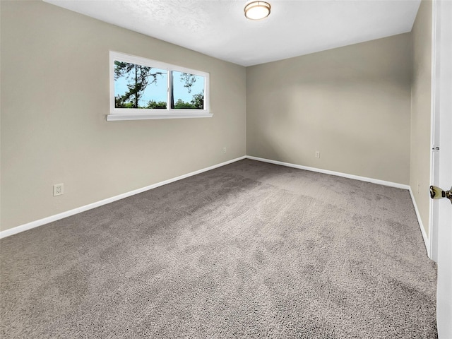 spare room featuring carpet and baseboards