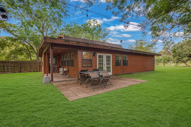 back of house featuring french doors, a patio area, and a lawn