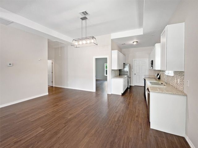 kitchen featuring white cabinets, backsplash, dark hardwood / wood-style flooring, pendant lighting, and sink