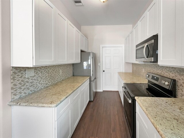 kitchen featuring white cabinetry, tasteful backsplash, light stone countertops, appliances with stainless steel finishes, and dark wood-type flooring