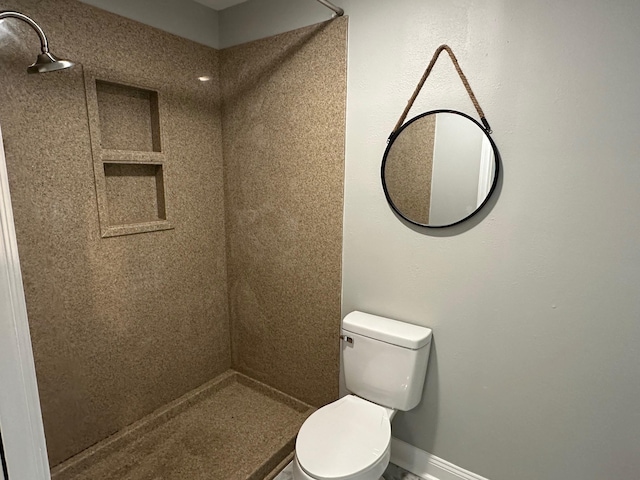 bathroom featuring toilet and a tile shower