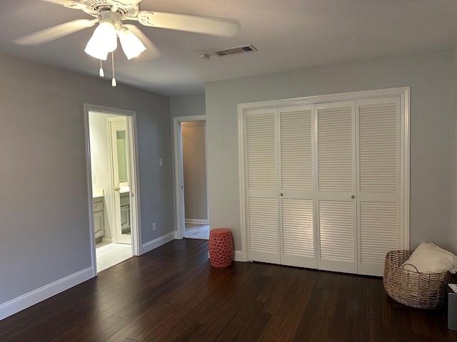 unfurnished bedroom featuring a closet, ceiling fan, and dark hardwood / wood-style flooring