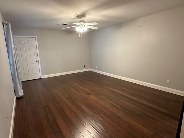 empty room featuring ceiling fan and dark hardwood / wood-style flooring