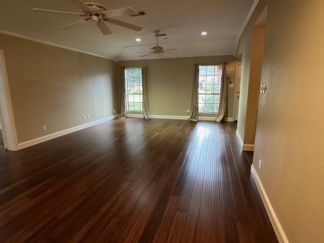 empty room featuring a wealth of natural light, dark hardwood / wood-style flooring, ceiling fan, and vaulted ceiling