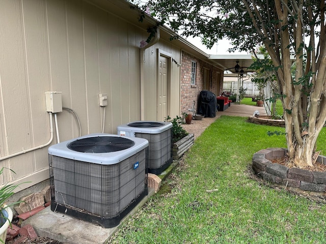 view of yard with central air condition unit, ceiling fan, and a patio