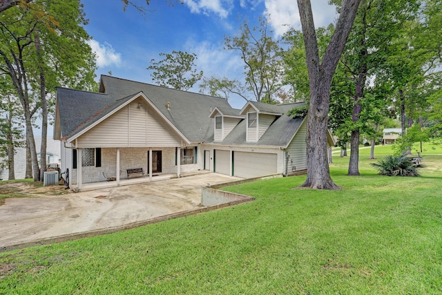 view of front of property with a garage, a front yard, and central air condition unit