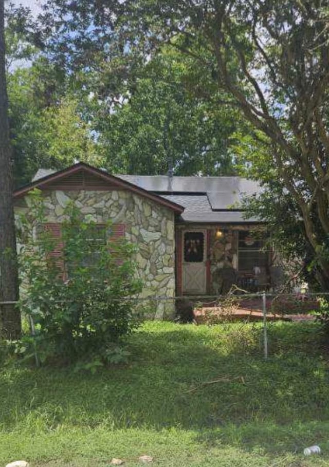 view of front of property with a front lawn and solar panels