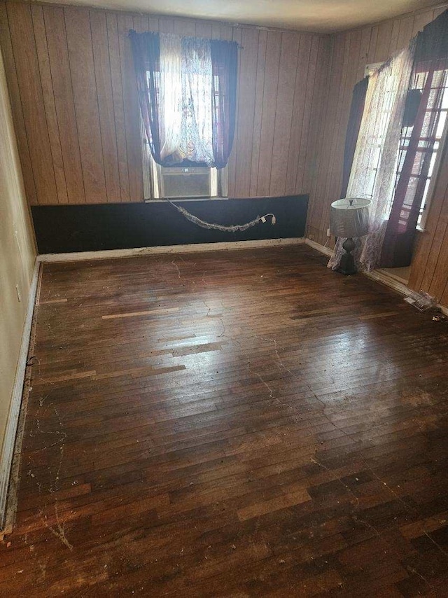 spare room featuring wood walls, dark hardwood / wood-style flooring, and cooling unit