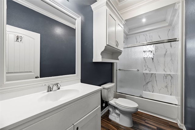 full bathroom featuring crown molding, hardwood / wood-style floors, oversized vanity, enclosed tub / shower combo, and toilet