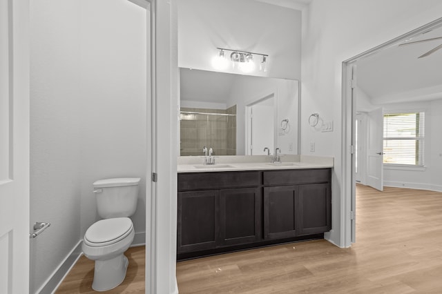 bathroom with wood-type flooring, toilet, ceiling fan, walk in shower, and vanity