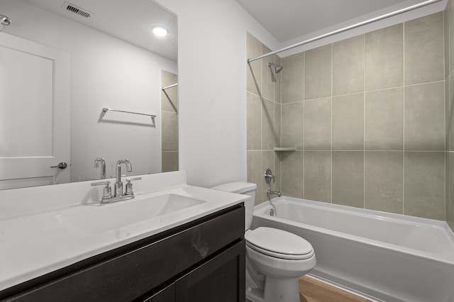 full bathroom featuring toilet, tiled shower / bath, hardwood / wood-style flooring, and vanity