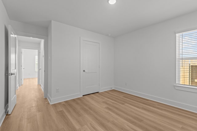 unfurnished bedroom with light hardwood / wood-style floors and a closet