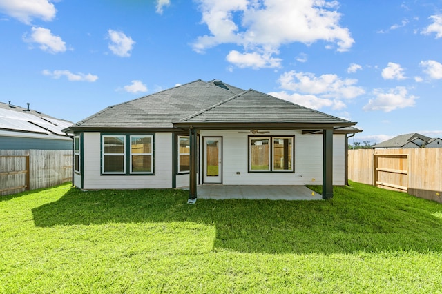 back of house featuring a patio area and a lawn