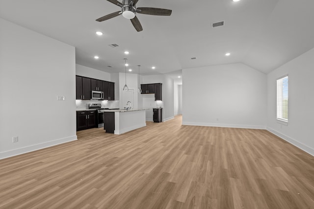 unfurnished living room with light hardwood / wood-style floors, ceiling fan, sink, and vaulted ceiling