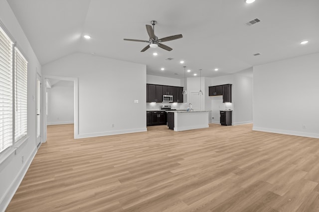 unfurnished living room featuring lofted ceiling, sink, light hardwood / wood-style flooring, and ceiling fan