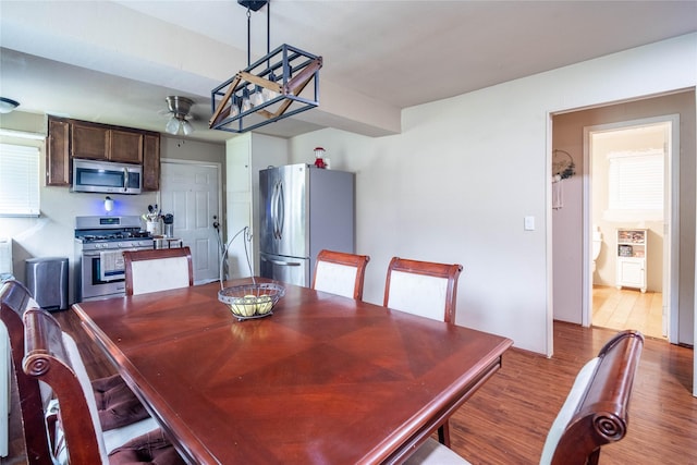 dining area with ceiling fan and wood-type flooring