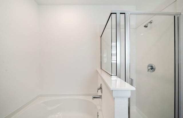 bathroom featuring shower with separate bathtub