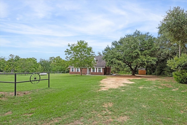 view of yard with a rural view and a shed