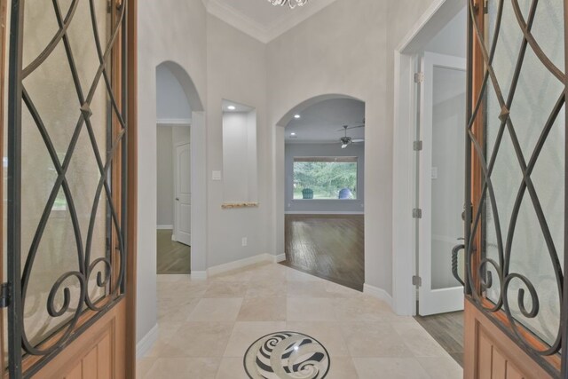 tiled entryway featuring ornamental molding and ceiling fan