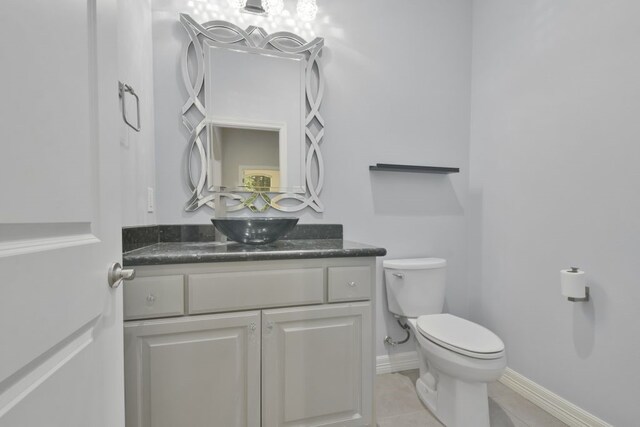 bathroom with tile flooring, toilet, and vanity