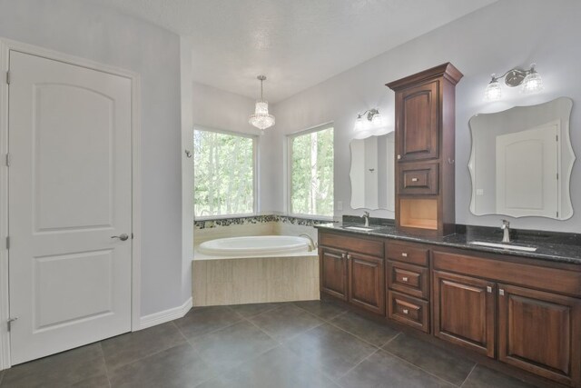 bathroom with double vanity, tile flooring, and a bathing tub