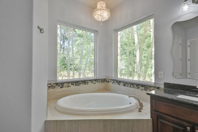 bathroom with tiled tub and vanity