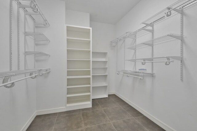 walk in closet featuring dark tile floors