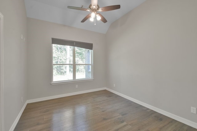 empty room featuring vaulted ceiling, hardwood / wood-style floors, and ceiling fan