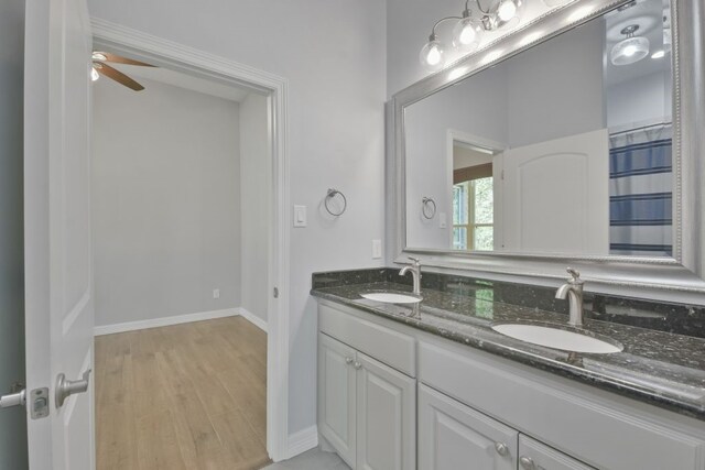 bathroom with dual vanity, ceiling fan, and hardwood / wood-style flooring