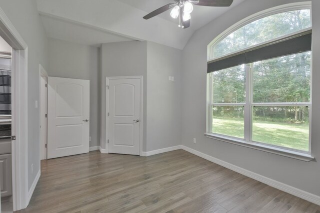 interior space featuring ceiling fan, light wood-type flooring, and lofted ceiling