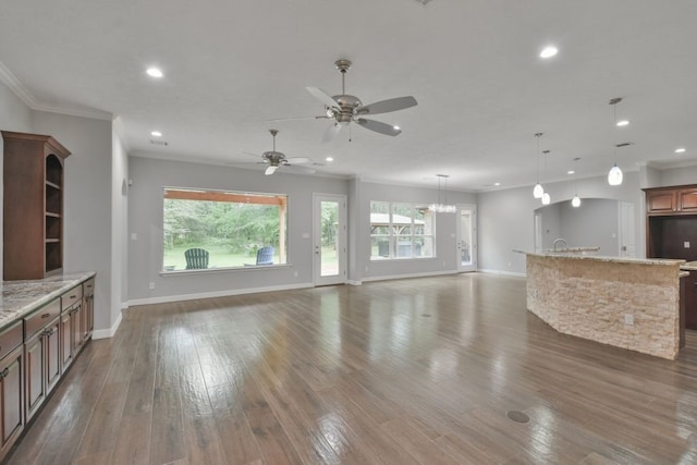 unfurnished living room featuring dark hardwood / wood-style floors, ornamental molding, and ceiling fan with notable chandelier