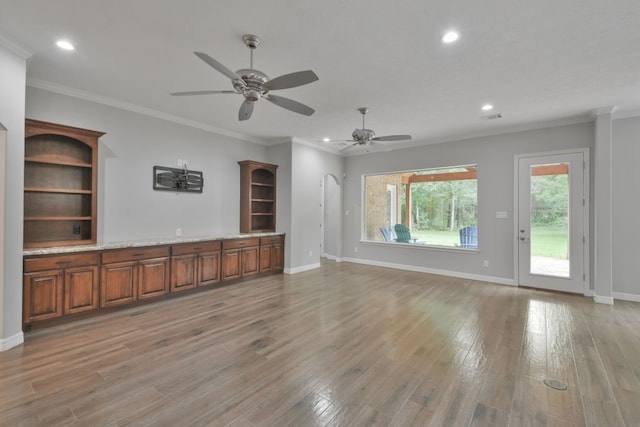 unfurnished living room with hardwood / wood-style flooring, ceiling fan, and ornamental molding