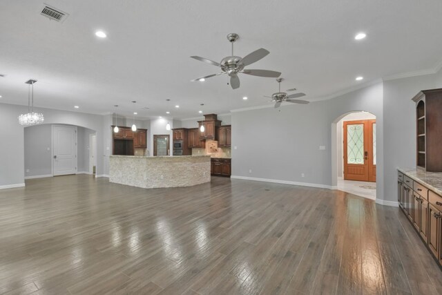 unfurnished living room featuring ornamental molding, hardwood / wood-style flooring, and ceiling fan with notable chandelier